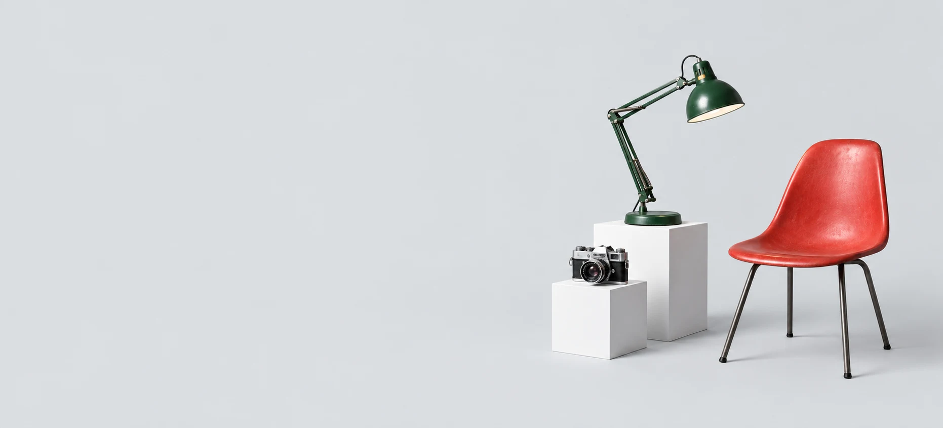 Une lampe verte, un appareil photo et une chaise rouge prêts pour une seconde vie.